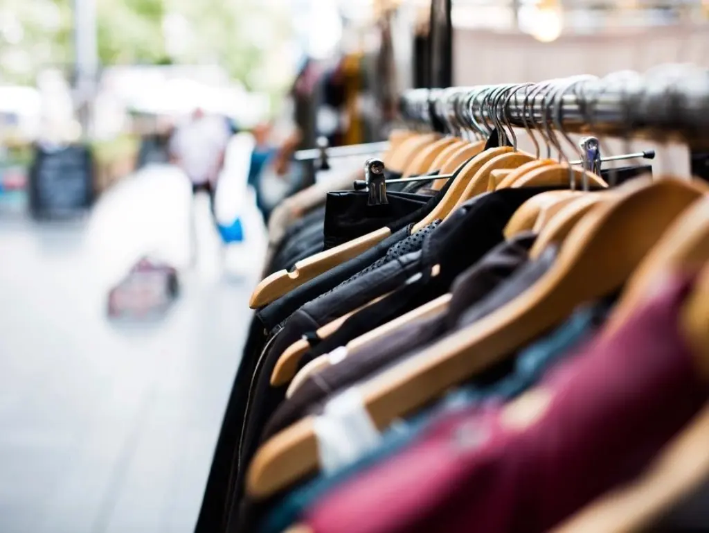 Clothing racks on wooden hangers inside a boutique