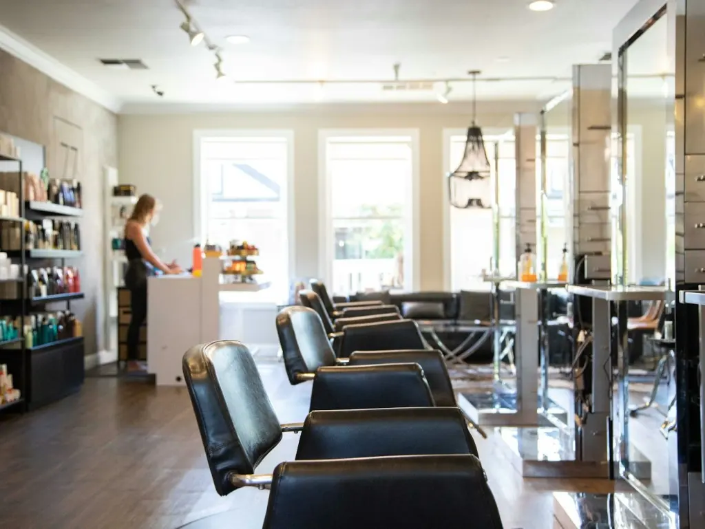 Bright hair salon with styling chairs lined up in front of mirrors